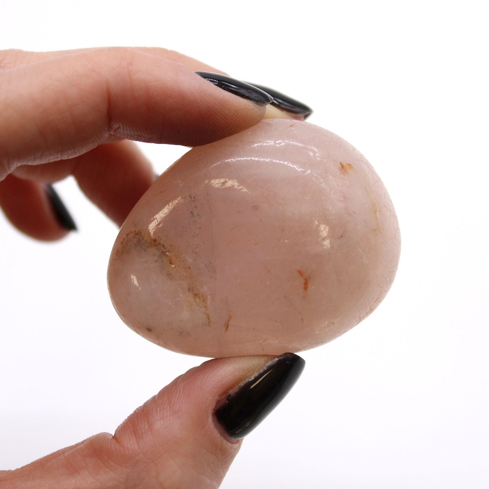 Alt Tag: Rose Quartz Tumble Stones – 6 Pcs Large African, polished rose quartz tumble stone held between fingers, pale pink African gemstone