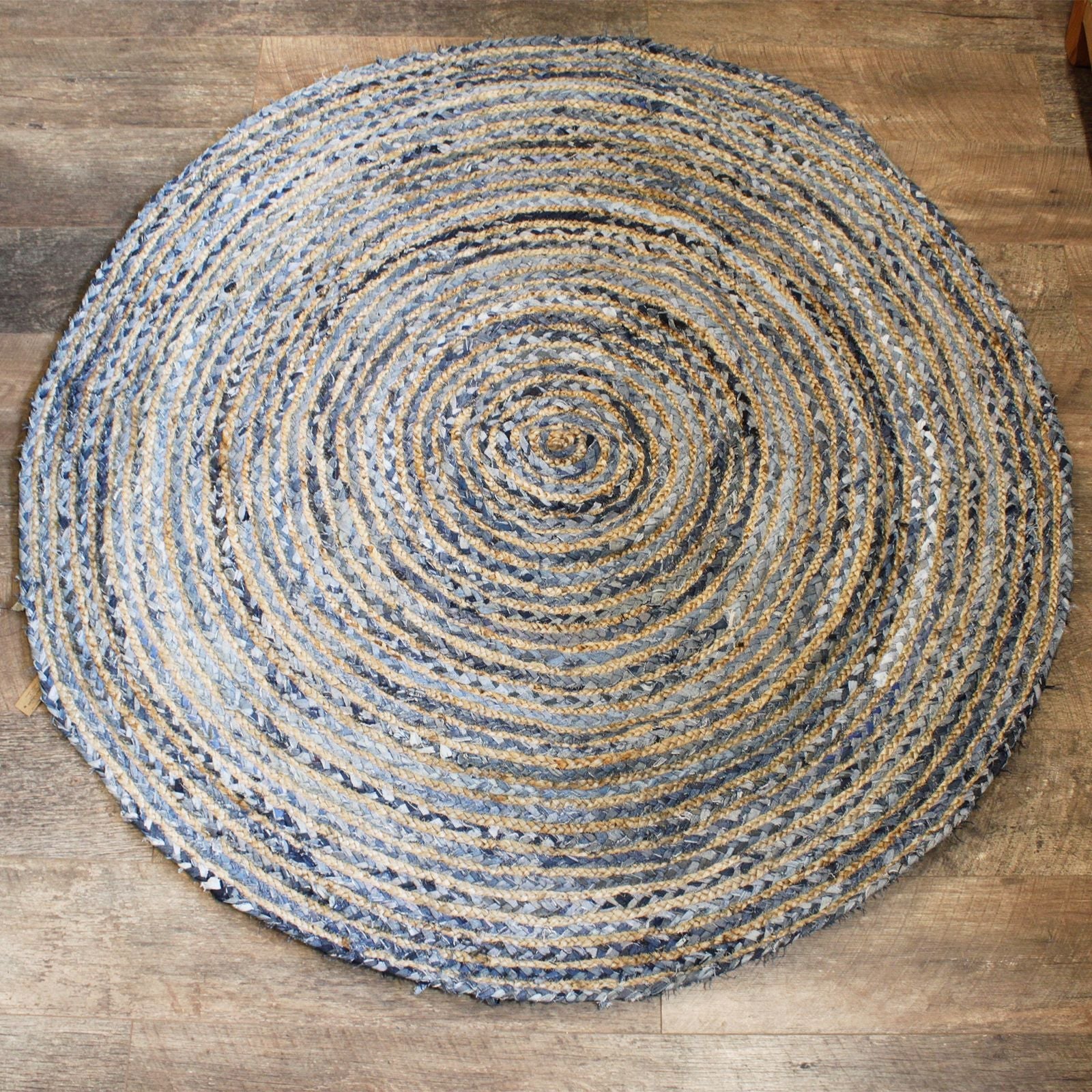 Alt Tag: Rund matta i jute och återvunnen denim – 150 CM, rund handvävd matta i jute och återvunnen denim i natur- och blå nyanser på trägolv