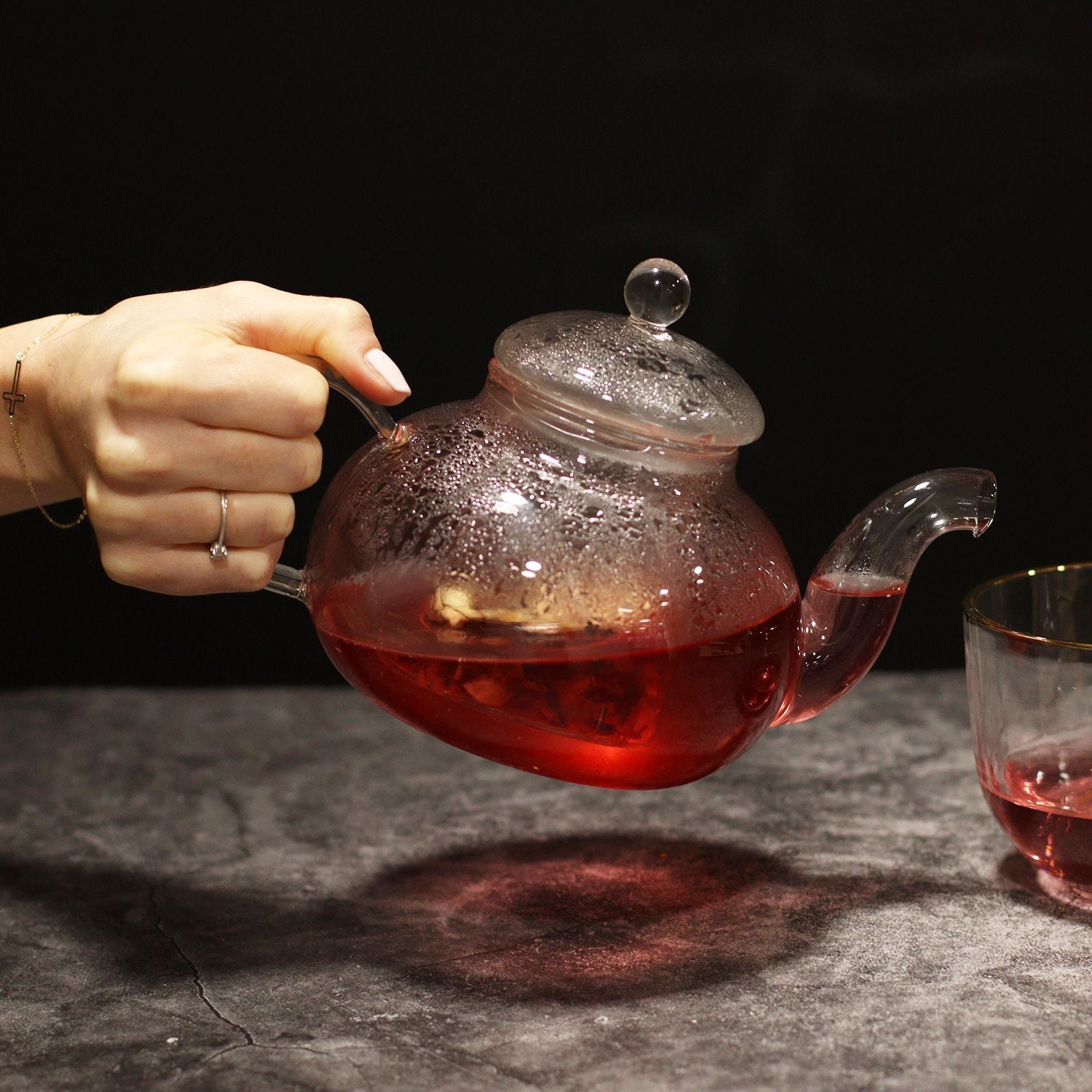 Alt Tag: Round Pearl Glass Infuser Teapot – 800ML glass teapot with infuser, red tea steeping, handheld pour on countertop
