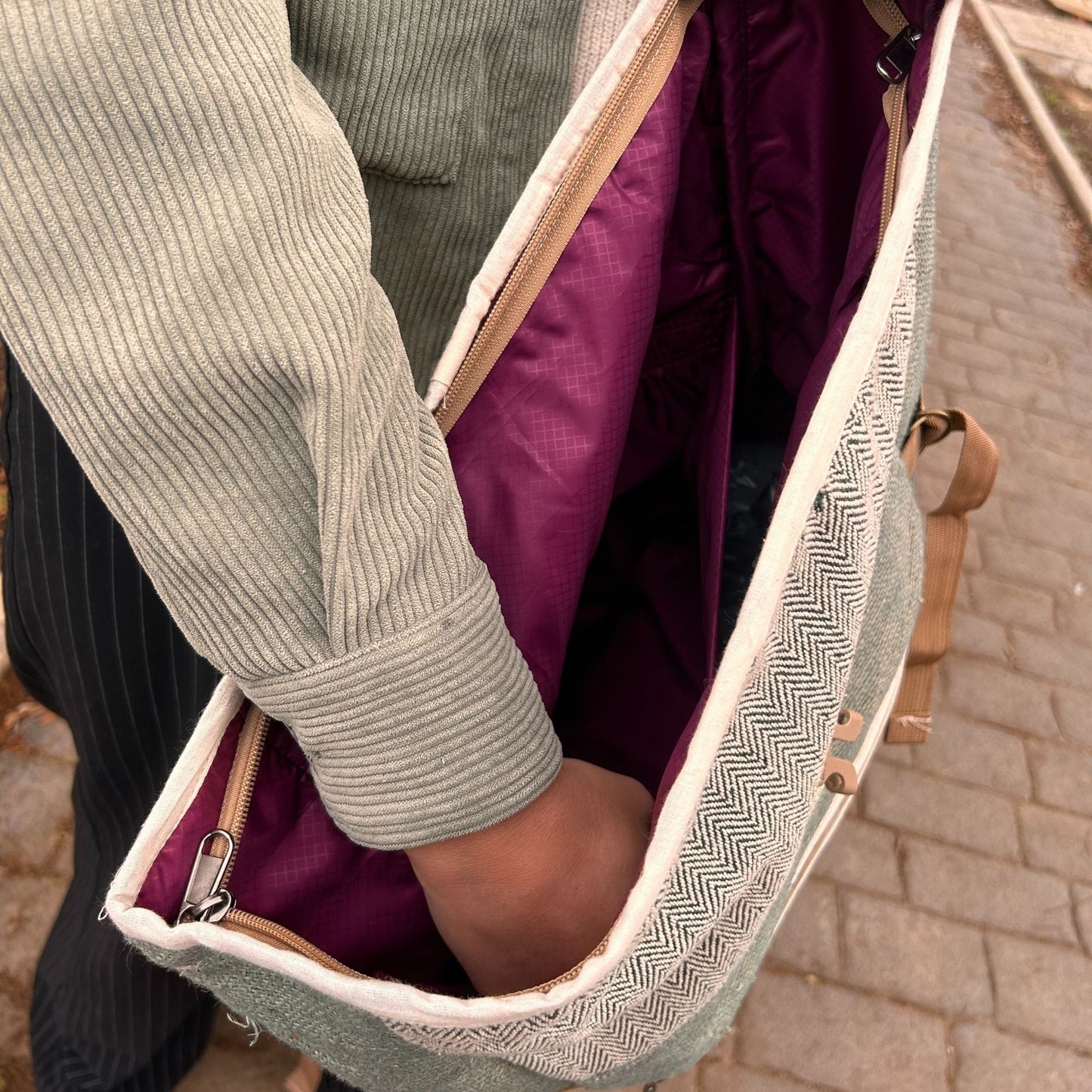 Sage Trekking Rolling Backpack – Hemp & Cotton Canvas open top view showing interior lining and hand placing items inside