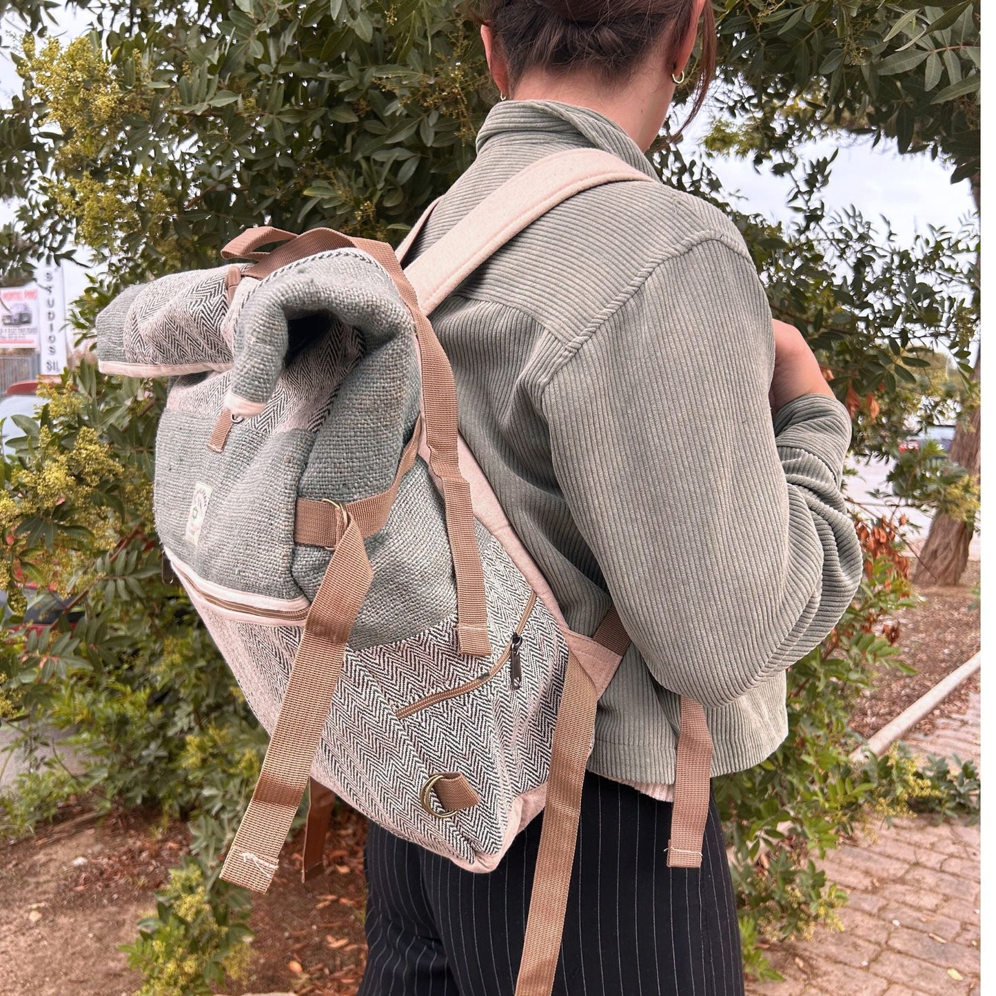 Alt Tag: Sage Trekking Rolling Backpack – Hemp & Cotton Canvas worn outdoors, sage canvas backpack with beige straps and flap top
