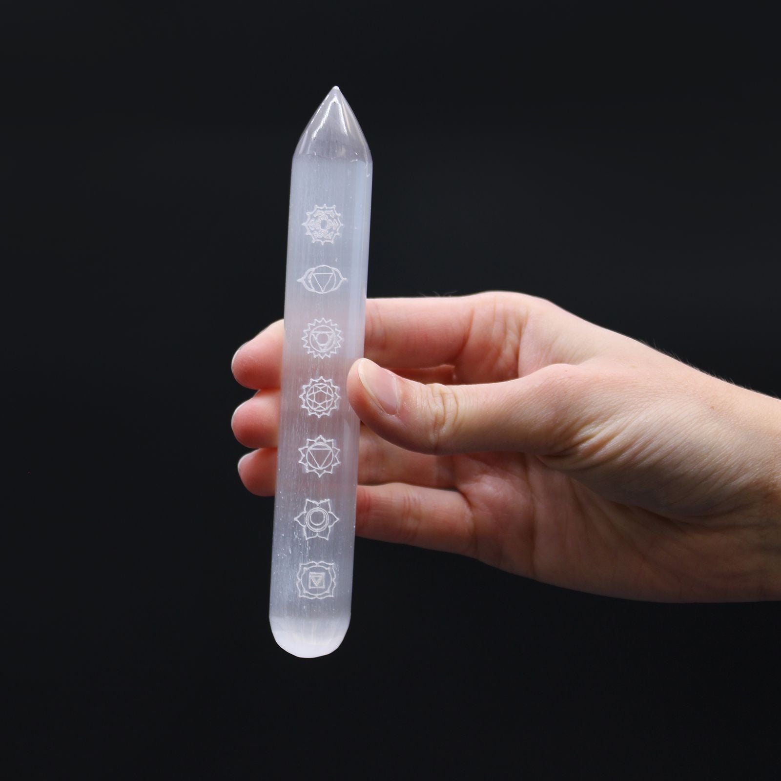Selenite Energy Wand – 14–16CM Chakra Point, white selenite crystal wand with etched chakra symbols, held in hand