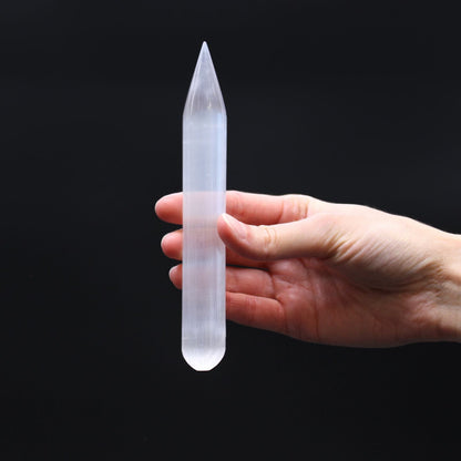 Alt Tag: Selenite Harmonizing Wand – 16 CM Pointed, pointed selenite wand crystal held in hand on black background