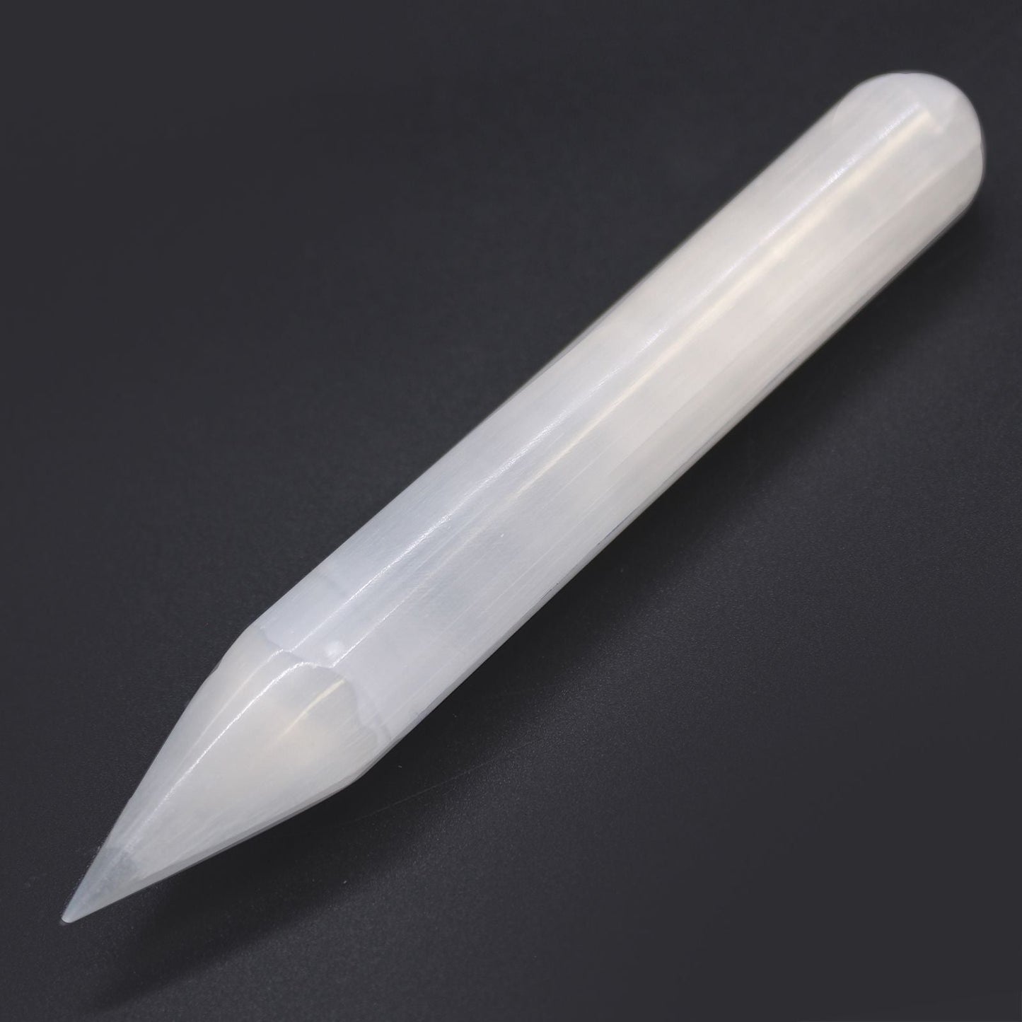 Alt Tag: Selenite Harmonizing Wand – 16 CM Pointed, varita de selenita blanca con punta, vista en diagonal sobre fondo oscuro