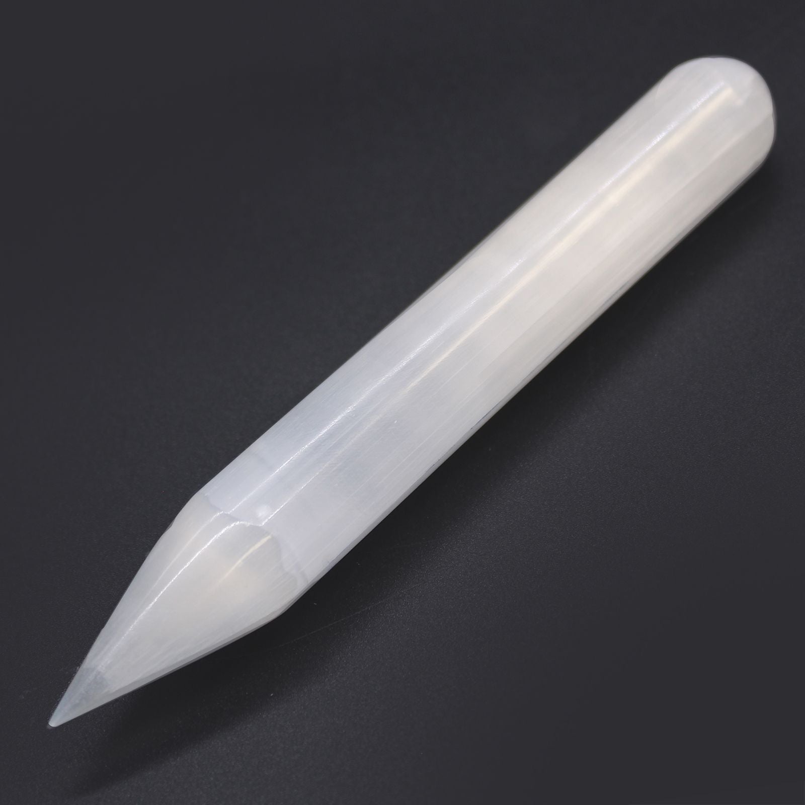 Alt Tag: Selenite Harmonizing Wand – 16 CM Pointed, varita de selenita blanca con punta, vista en diagonal sobre fondo oscuro