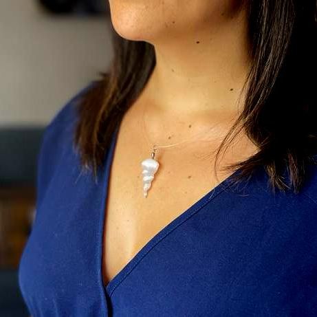 Alt-Tag: Selenit-Spiralanhänger – 4x1,5 CM transluzenter Selenit-Spiralanhänger an einer Halskette, getragen über einer blauen Bluse