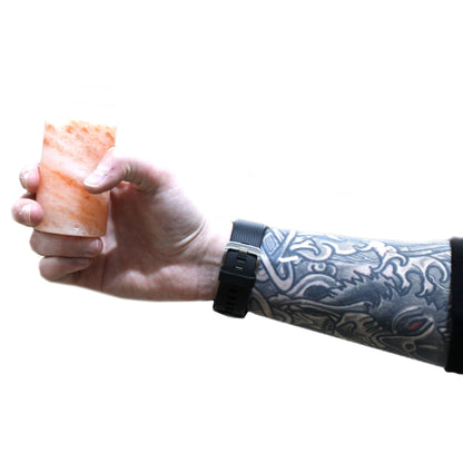 Alt Tag: Set med 4 Himalayasalt-shotglas med serveringsställ i trä, hand som håller ett shotglas av Himalayasalt i närbild