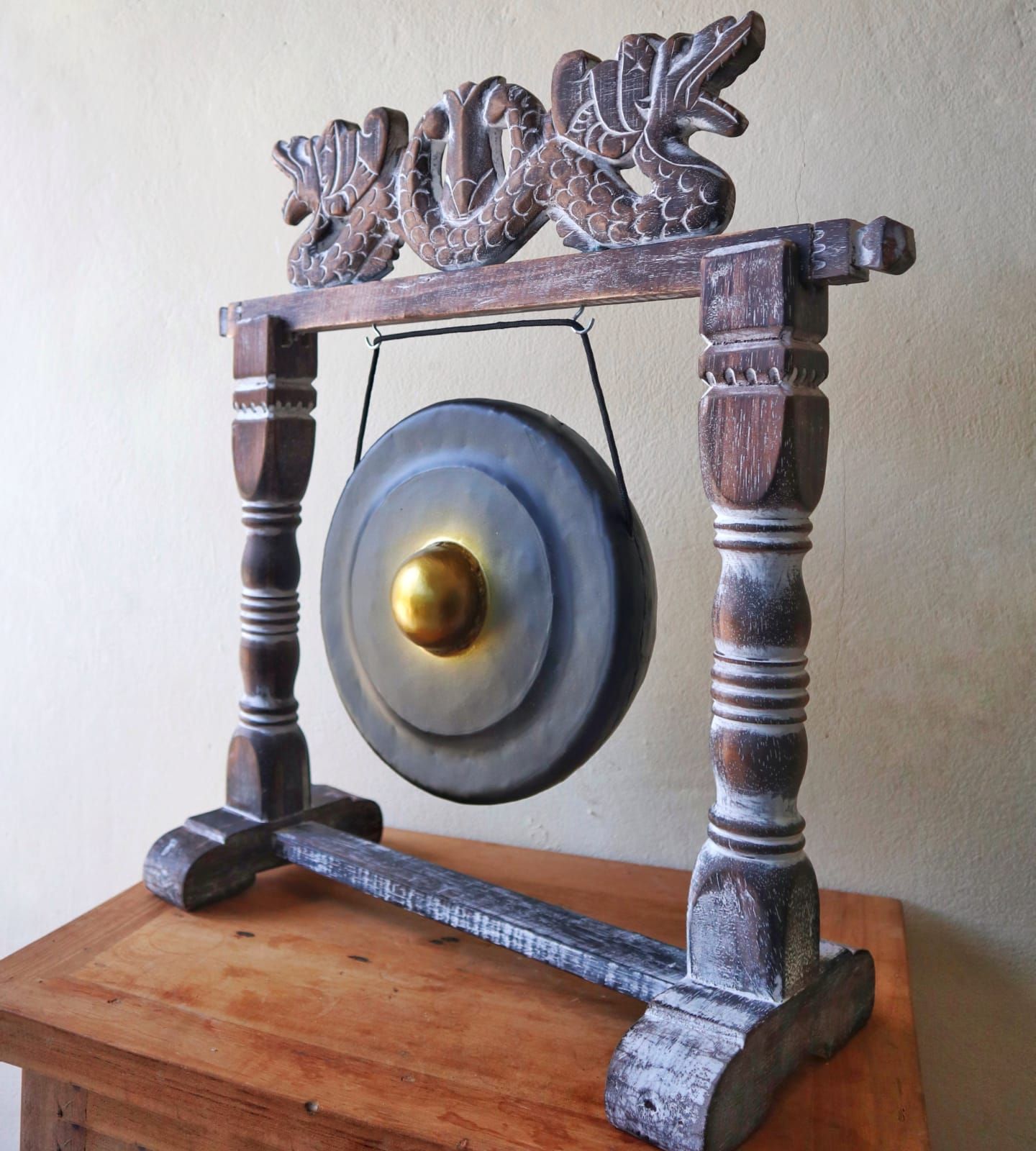 Small Harmonizing Gong in Stand – 25 CM – Black, handcrafted black gong with carved wooden stand displayed on a wooden table