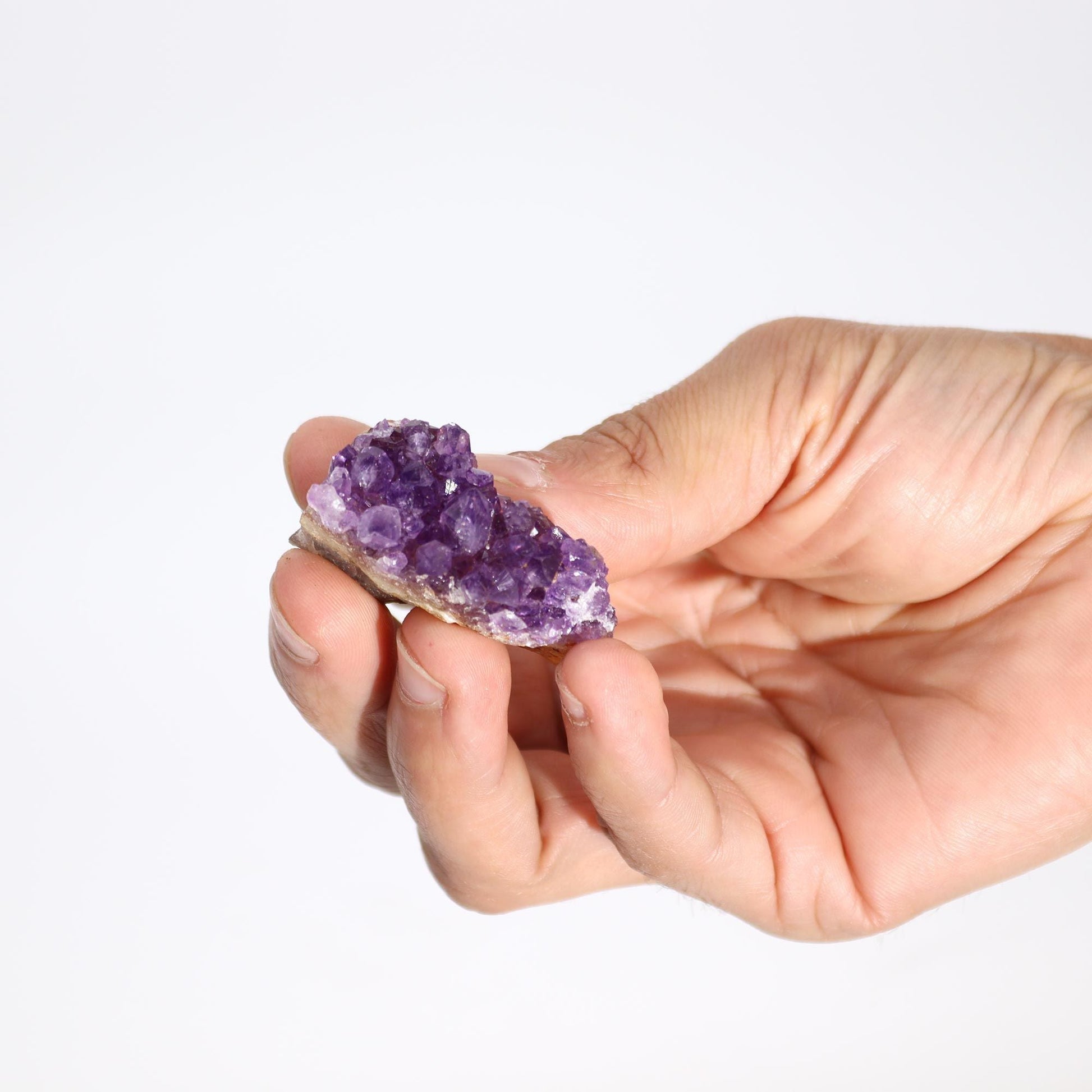 Small Natural High-Grade Amethyst Cluster (Approx. 3–8 CM) sostenido en la mano, racimo natural violeta con puntas de cristal