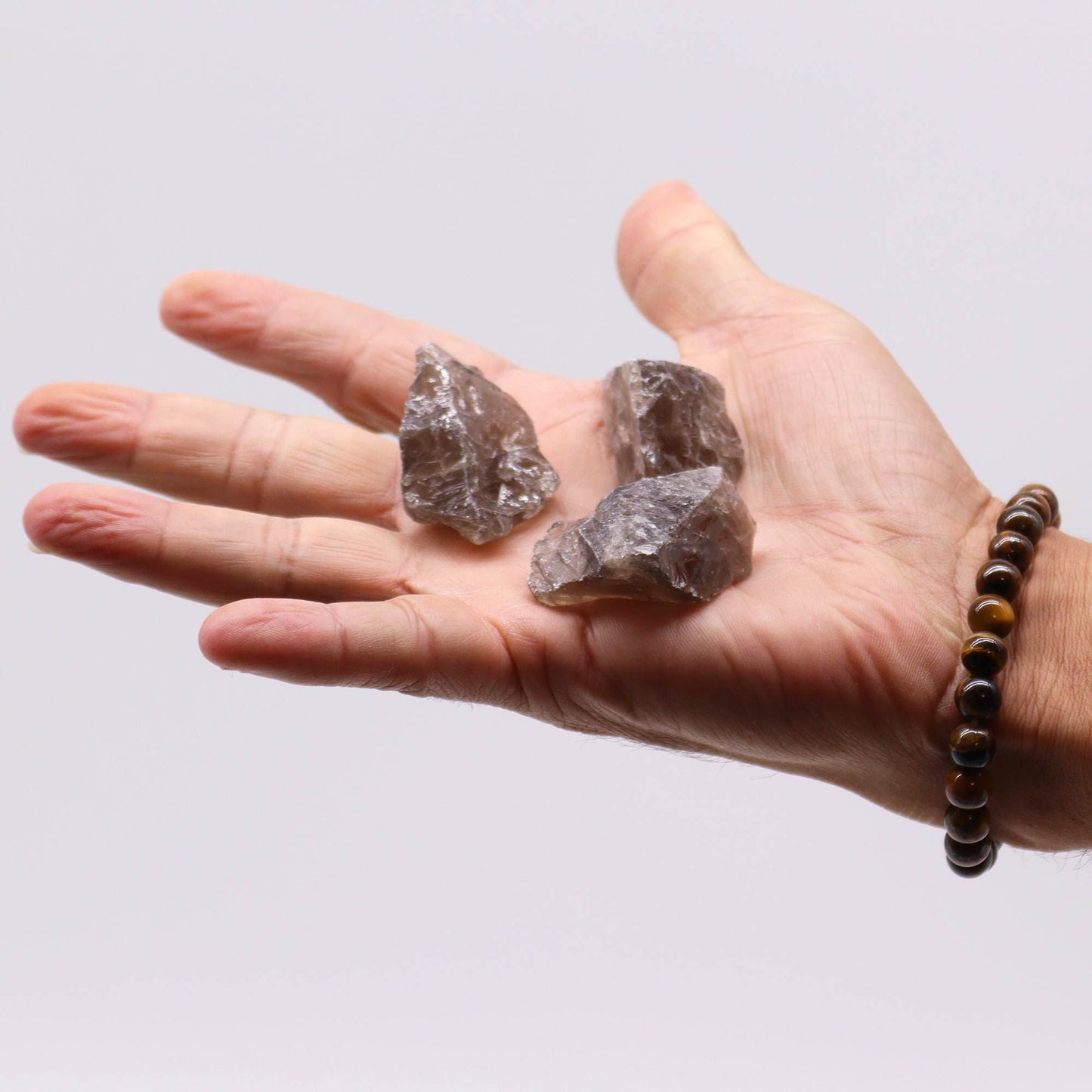 Smoky Quartz Raw Crystals – 500G Gemstone Collection, raw smoky quartz stones held in hand on white background