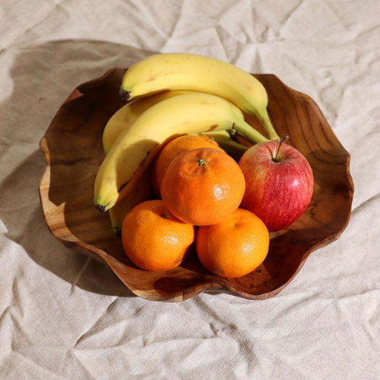 Alt Tag: Slät rund fruktskål i teakträ – 28 × 5.5 CM med bananer, apelsiner och ett äpple på ett matbord