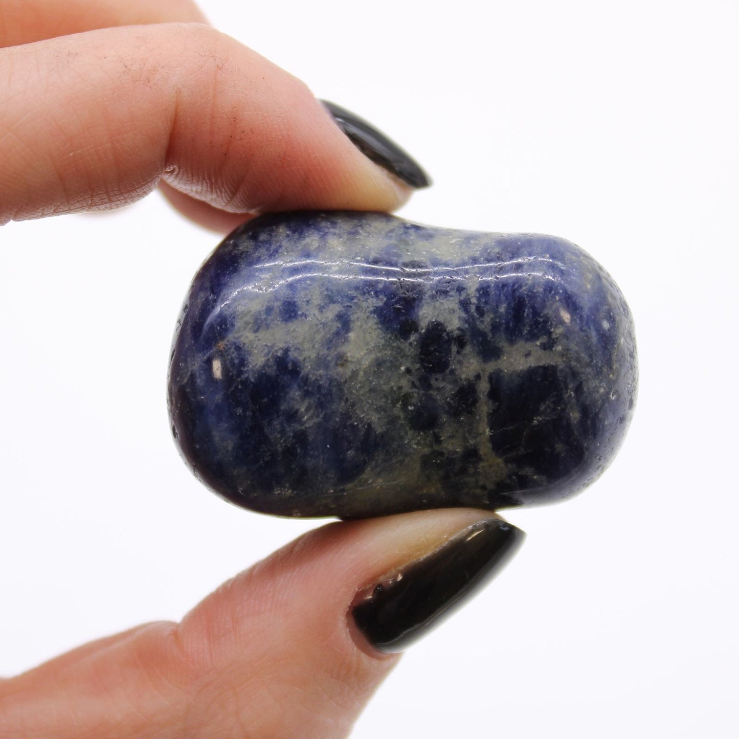 Sodalite Gemstone Tumble Stones – Large Bag of 6, close-up of blue sodalite tumbled stone held between fingers