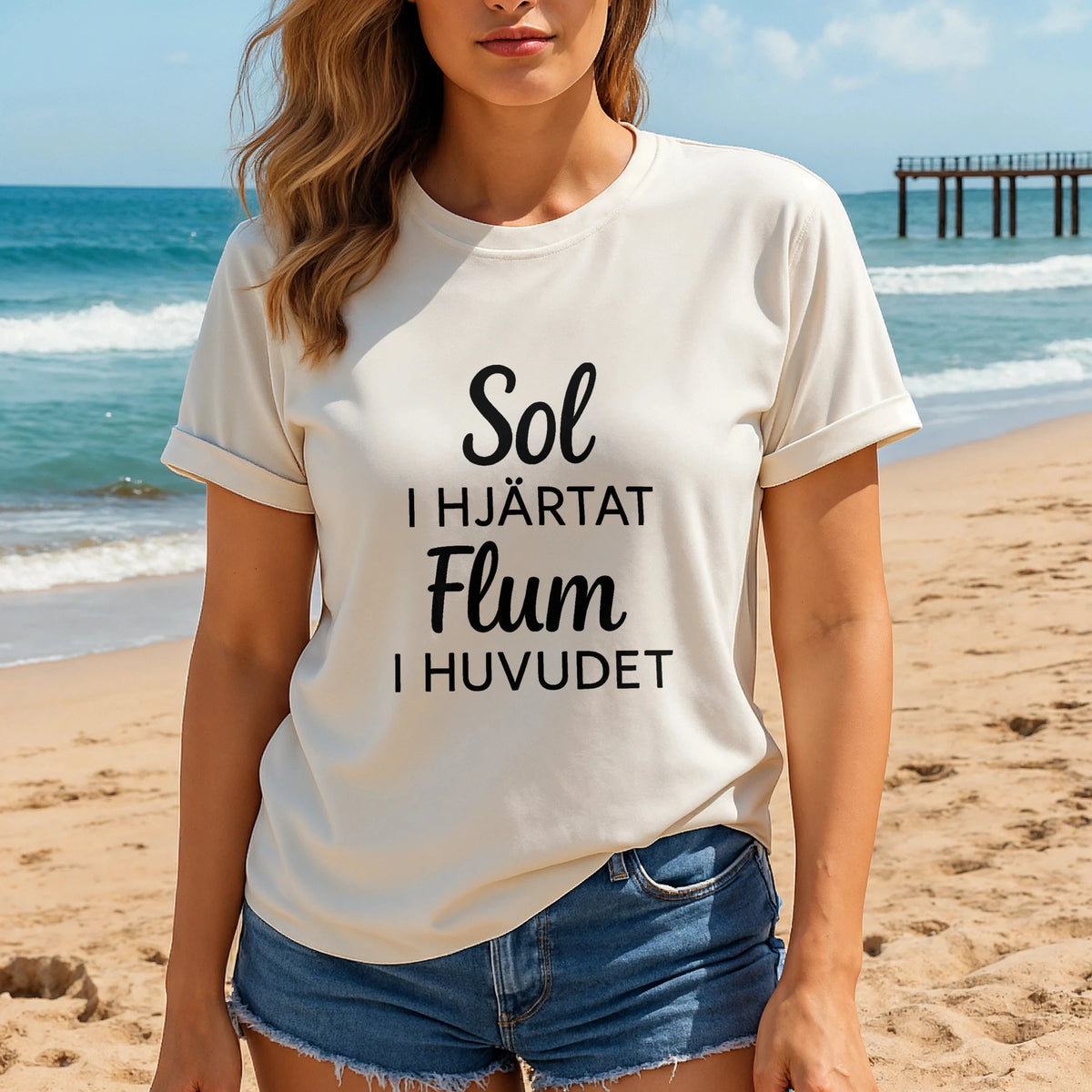 Sol I Hjärtat Flum I Huvudet 100% Organic Cotton T-Shirt on woman at beach, white tee with black Swedish text print
