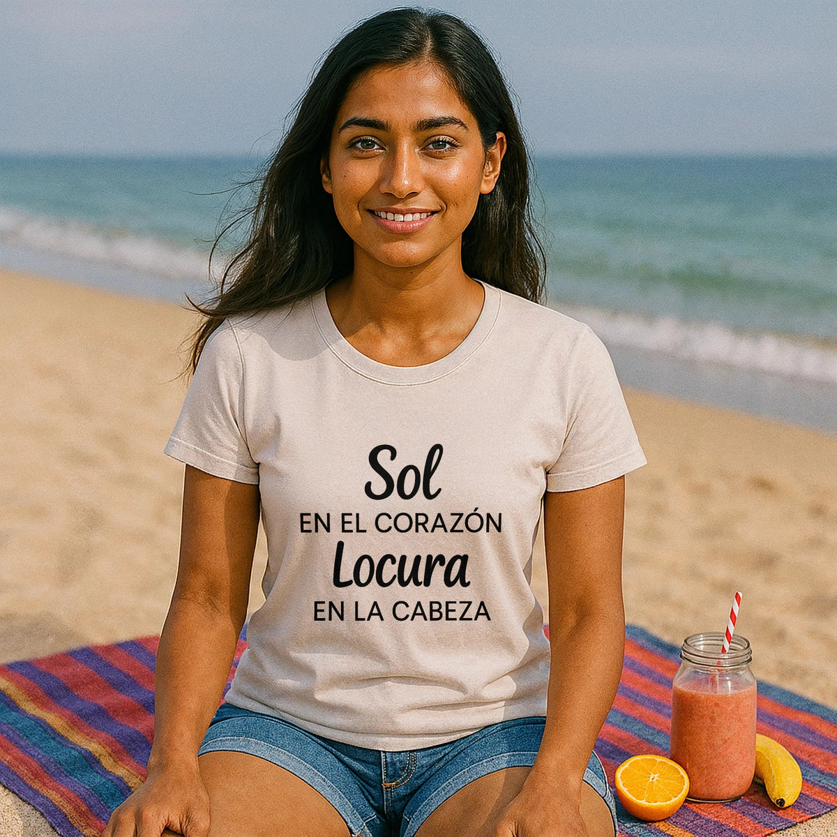 Alt Tag: Sol Locura 100% Organic Cotton T-Shirt en modelo sentada en la playa, camiseta beige con texto “Sol Locura”