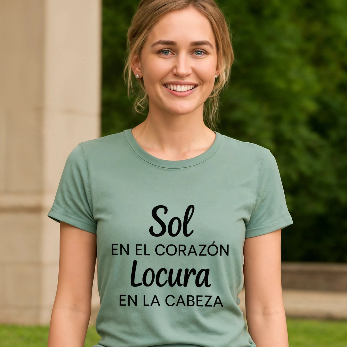 Alt Tag: Sol Locura 100% Organic Cotton T-Shirt mujer con camiseta verde salvia con texto “Sol en el corazón, locura en la cabeza”