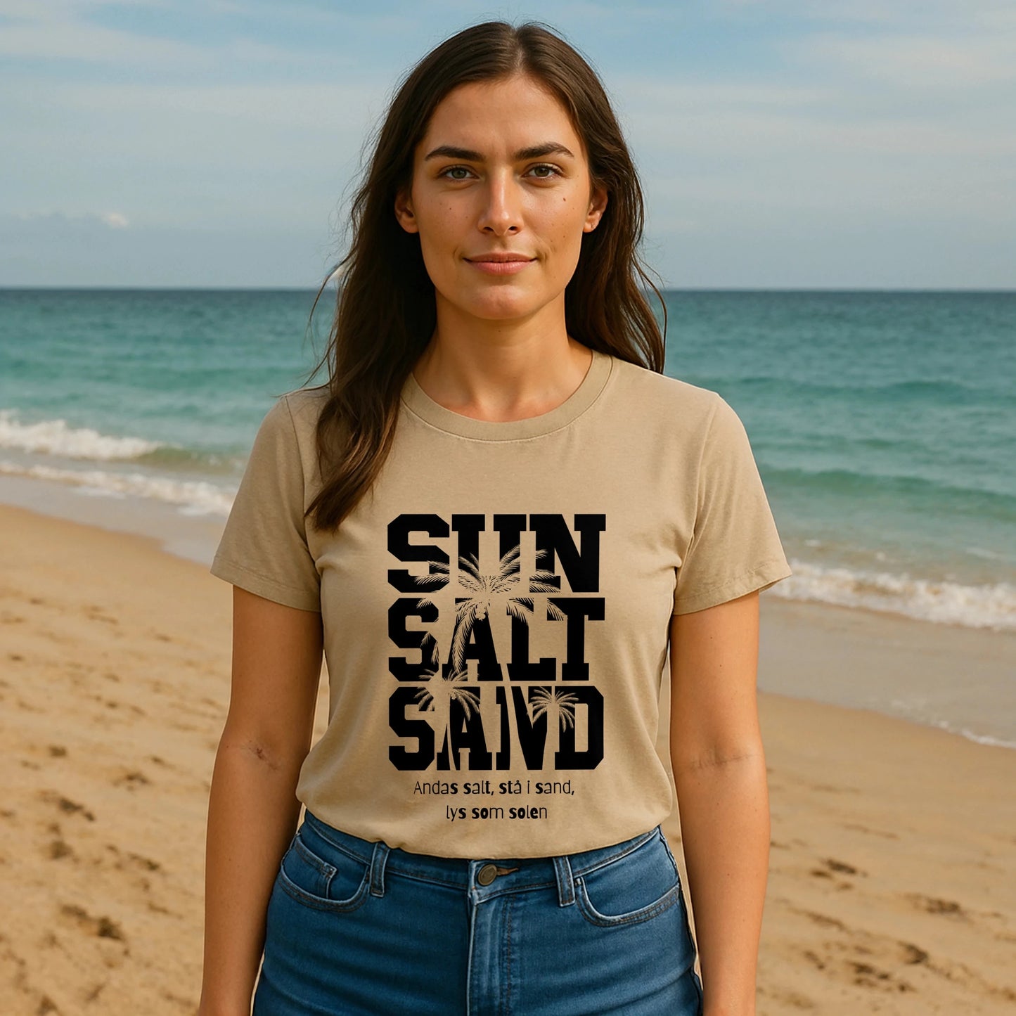 Alt Tag: Sol Salt Sand 100% Organic Cotton T-Shirt en modelo en la playa, camiseta beige con estampado “SUN SALT SAND” al frente