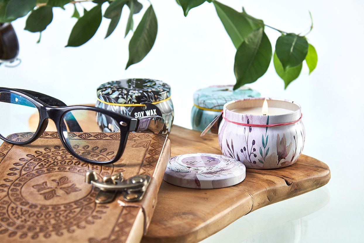 Soy Wax Art Tin Candle – Friendly Messages in decorative tin on wooden tray with glasses, notebook and leafy decor
