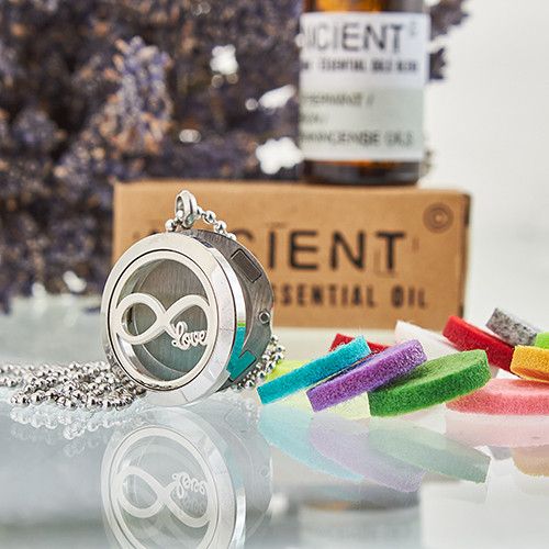 Stainless Steel Infinity Love Aromatherapy Necklace – 25MM diffuser locket with chain, felt pads and essential oil bottle in background