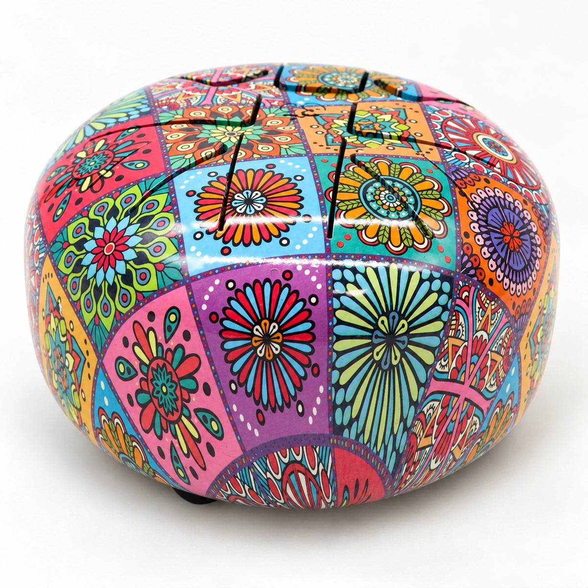 Lower three-quarter view of the colourful steel tongue drum, showing its domed top and rounded floral sidewall.
