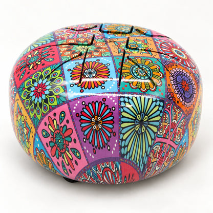 Lower three-quarter view of the colourful steel tongue drum, showing its domed top and rounded floral sidewall.