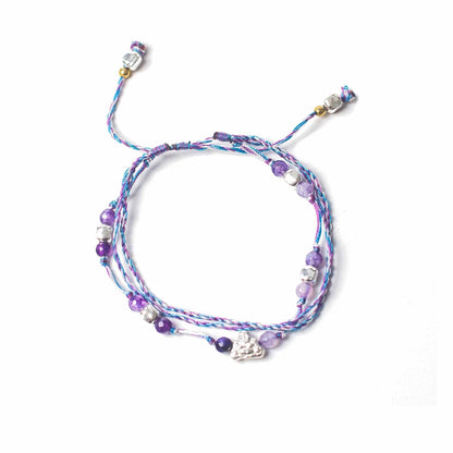 String & Beads Temple Bracelet – One Size adjustable braided string bracelet with metal accents and purple beads, top view on white