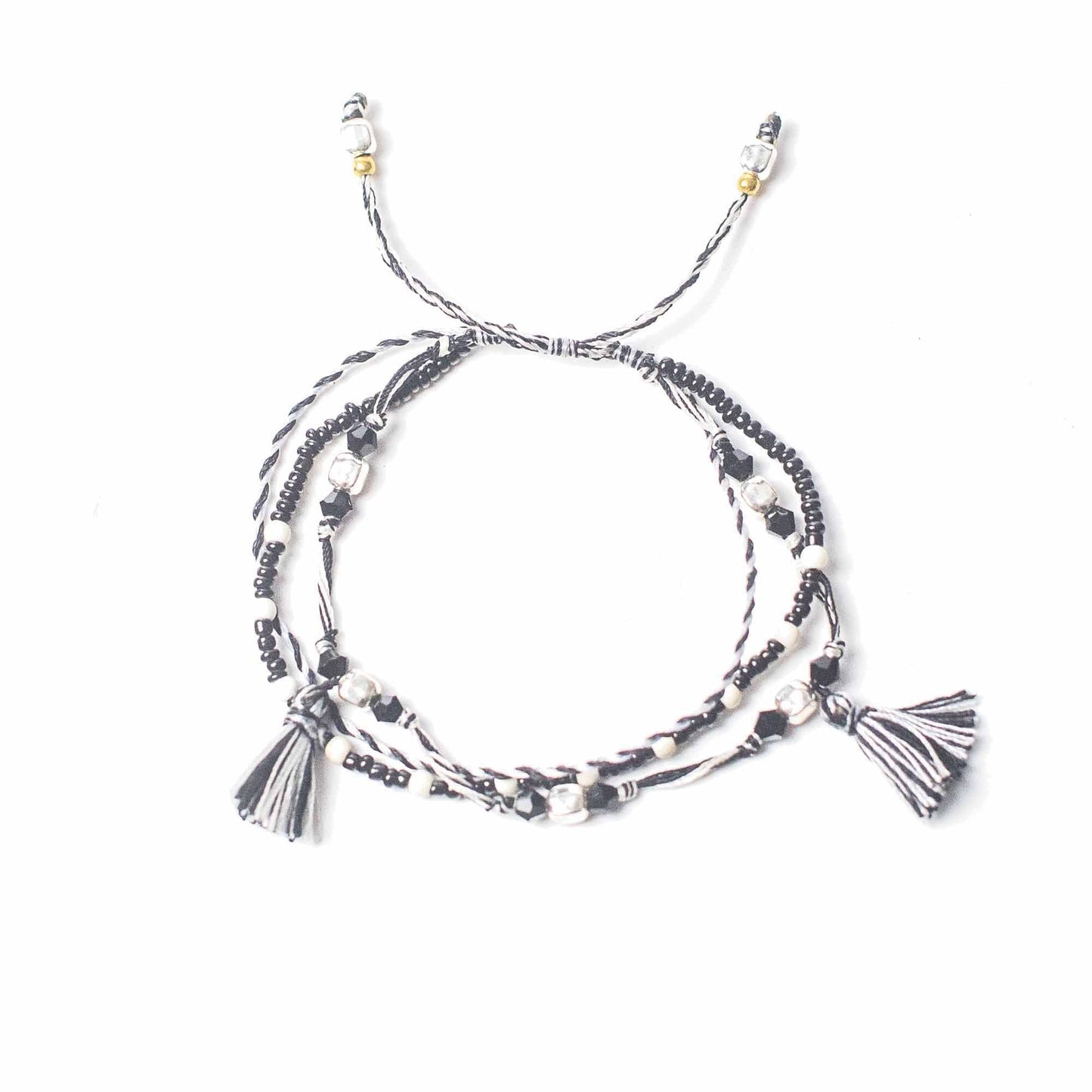 String & Beads Temple Bracelet – Balance of Nature, black and white string bracelet with metal beads and tassel ends on white background