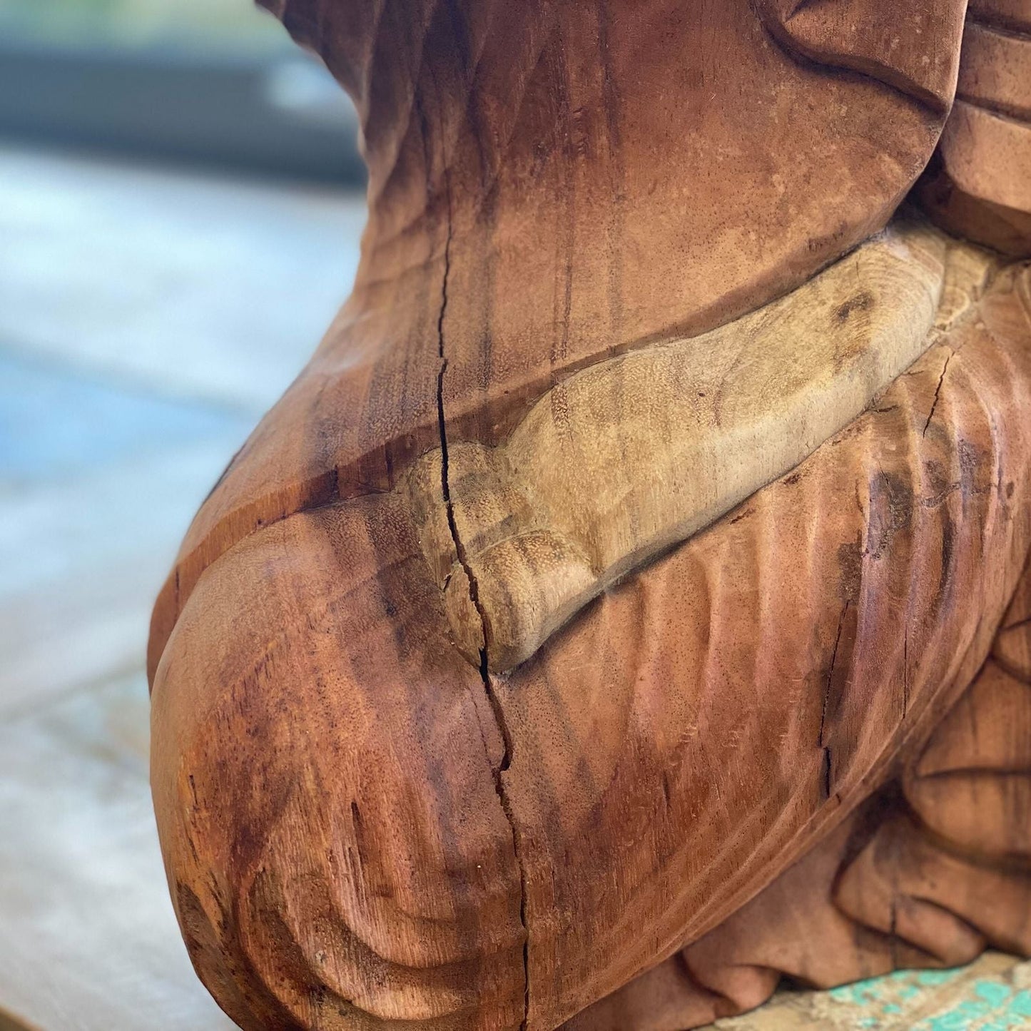 Handskuren Buddha-staty i suarträ – 80CM närbild av den snidade trädräkten och den naturliga ådringen på Buddhafiguren