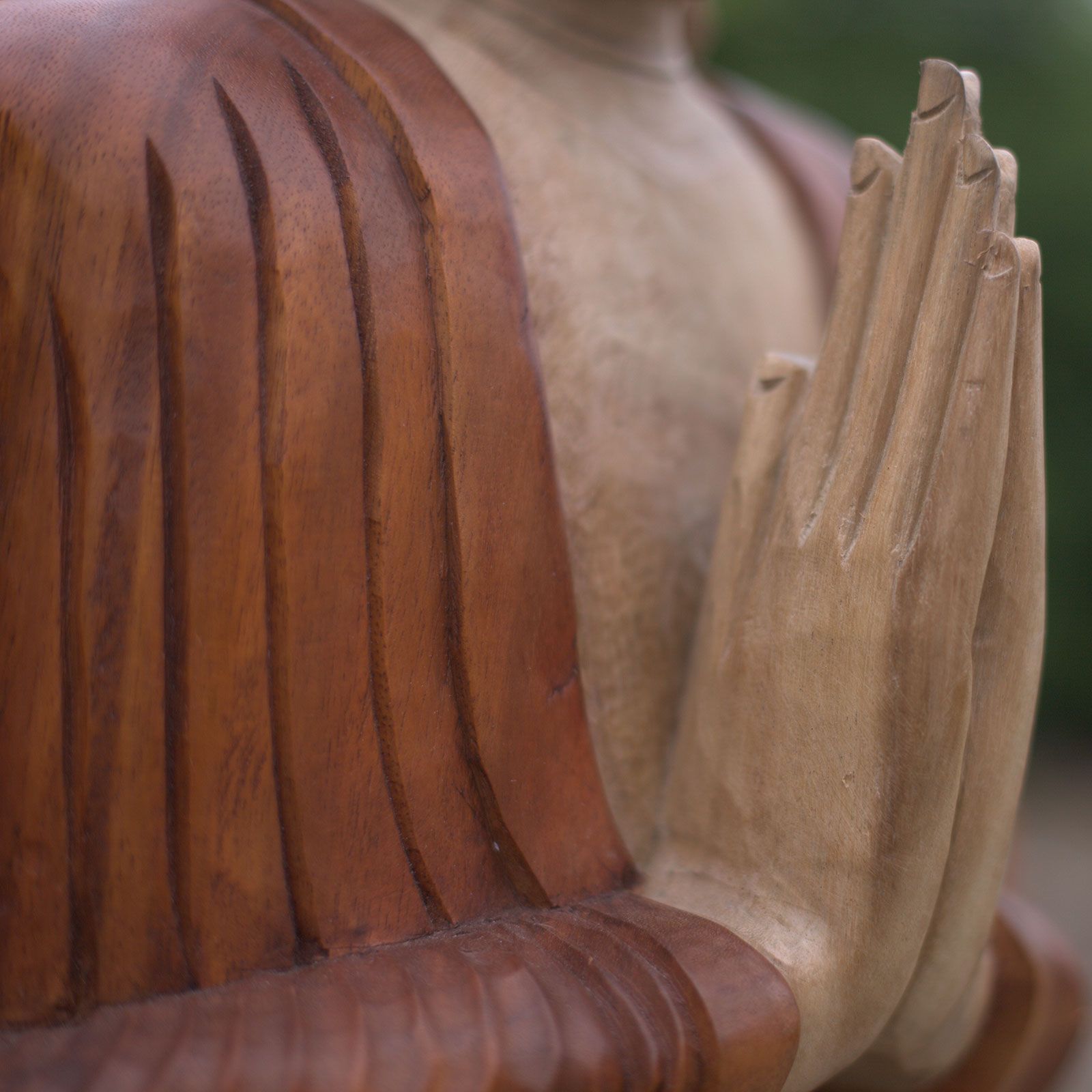 Handskuren Buddha-staty i suarträ – 80CM närbild på snidade trä händer i bön och detalj av draperad kåpa