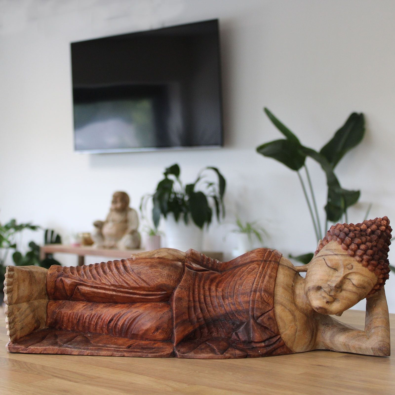 Sovande Buddha-staty i suarträ – 50CM handskuren liggande Buddha-dekorskulptur i suarträ på träbord