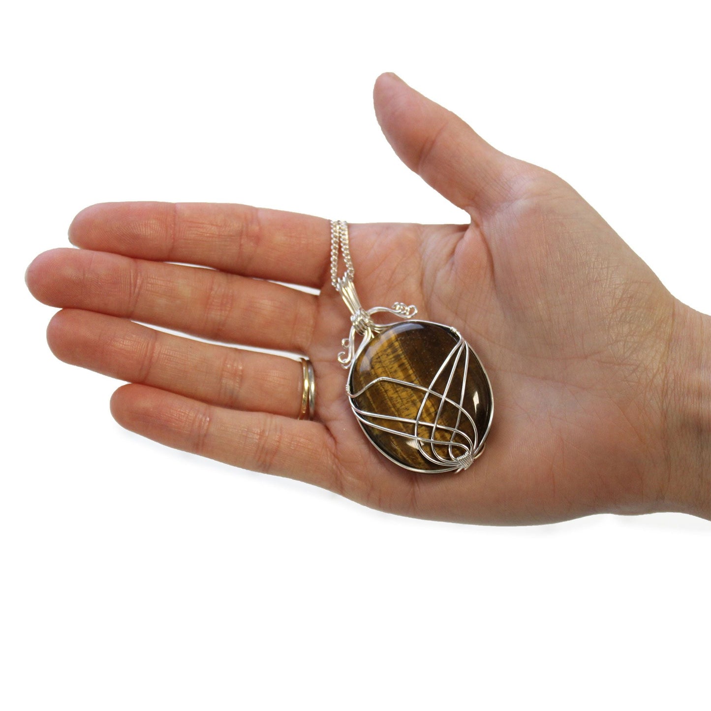 Swirl Wrapped Gemstone Necklace – Tiger Eye pendant with golden-brown tiger eye stone and silver swirl wire wrap on chain, held in hand