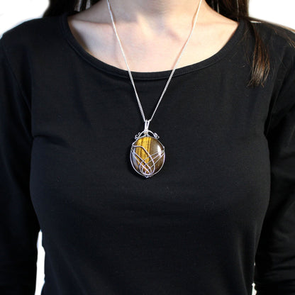 Alt Tag: Swirl Wrapped Gemstone Necklace – Tiger Eye pendant in silver swirl wire wrap with golden-brown tiger eye gemstone on model