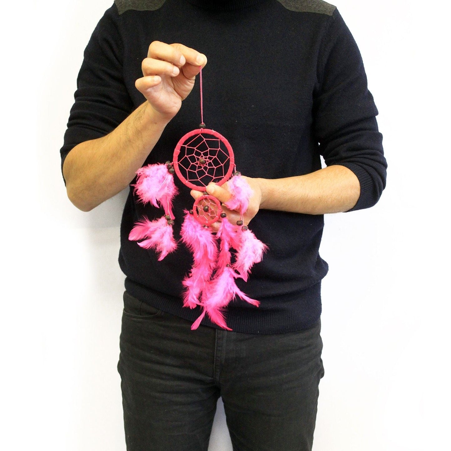 Alt Tag: Syntetisk mocka Bali Dream Catcher – Medium 10CM rosa drömfångare med fjädrar och pärlor som hålls av en person