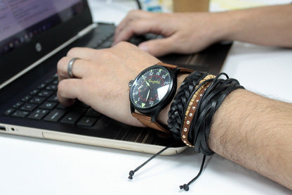Alt Tag: Tanned Leather & Metal Bracelet Set – Adjustable Design on men's wrist, leather and metal bracelets stacked while typing on laptop