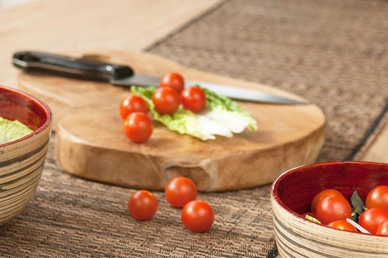 Skärbräda i teak – 40 CM av teakträ med körsbärstomater, kniv och sallad på köksbänk