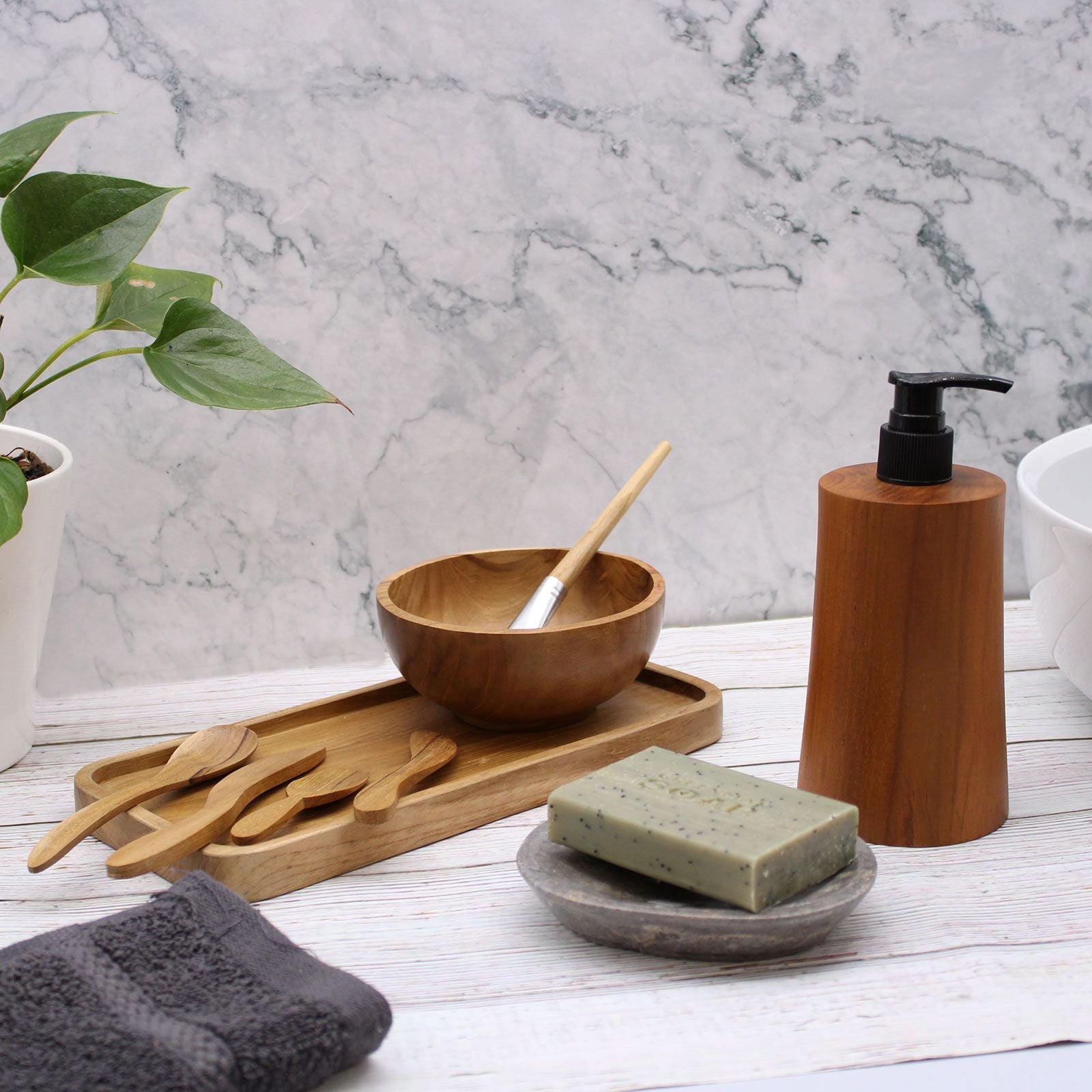 Alt Tag: Teakwood Soap Dispenser – Taper Design con bomba negra sobre encimera de baño junto a jabón en barra y accesorios de madera