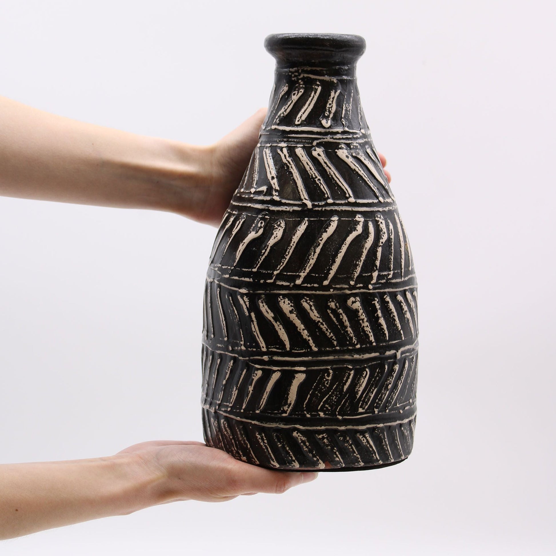 Terracotta Greek Taper Vase – 31x15 CM en color chocolate, jarrón artesanal de terracota con relieve geométrico, sostenido en manos