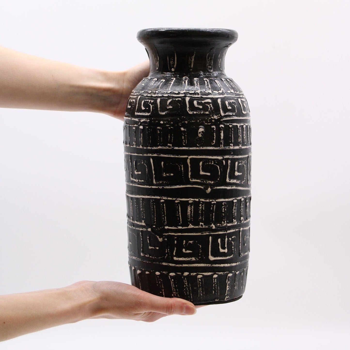Alt-Tag: Terrakotta-Griechische Vase – 32x15 CM, schwarze Terrakotta-Vase mit griechisch inspirierten geometrischen Bändern, in Händen gehalten vor weißem Hintergrund