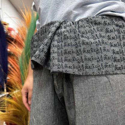 Alt Tag: Yoga- och festivalbyxor – Thai Fisherman Mandala Mantra i grått, närbild på grå yoga-wrapbyxor med omlottmidja och sanskritmantra-tryck
