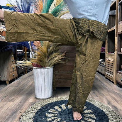 Yoga- och festivalbyxor – Thai Fisherman Mandala Mantra on Orange burna i yogaposition, thailändska fisherman-wrapbyxor med mandala-mantra-tryck
