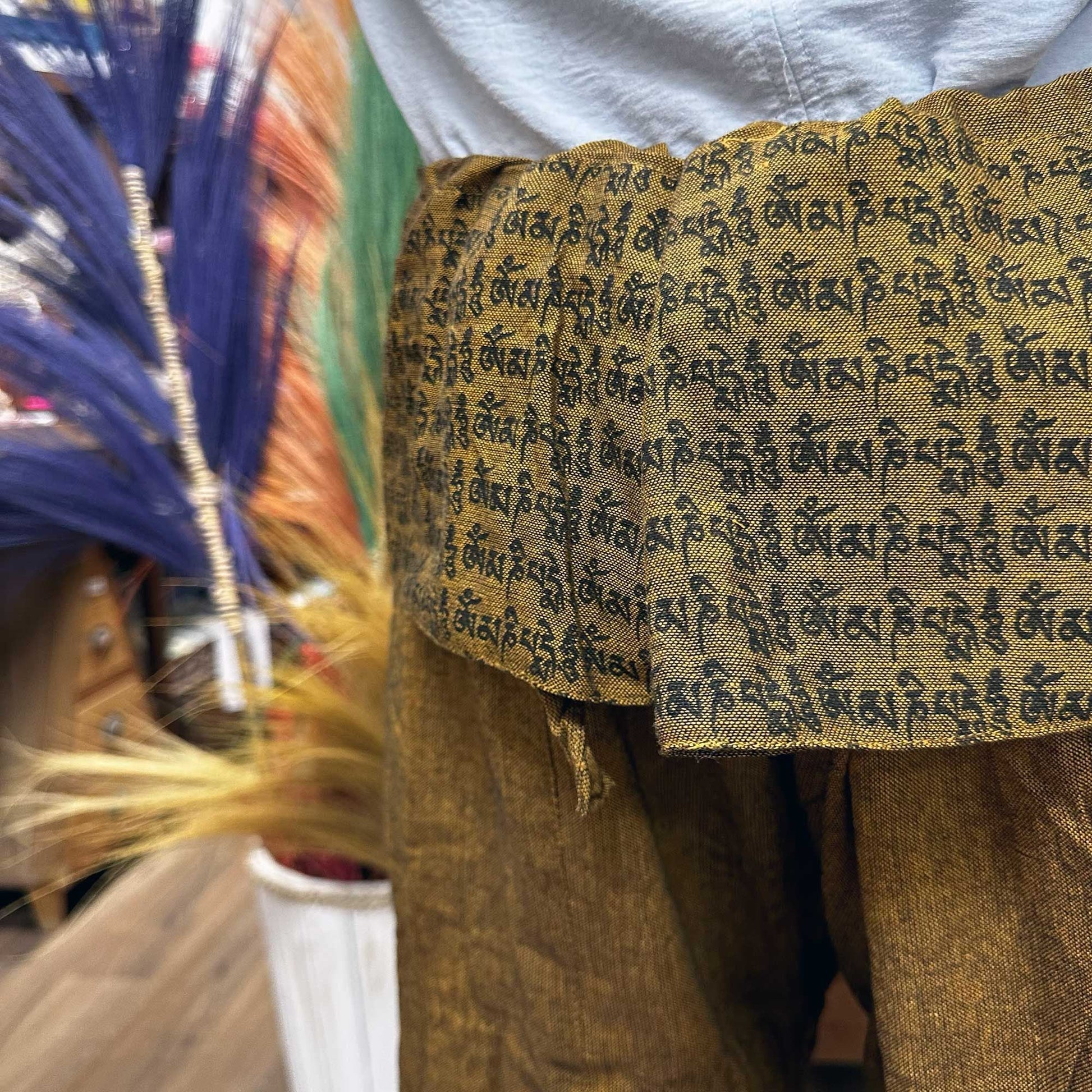 Yoga- och festivalbyxor – Thai Fisherman Mandala Mantra på orange, närbild av midjeomslag med sanskritmantra-tryck på orange tyg