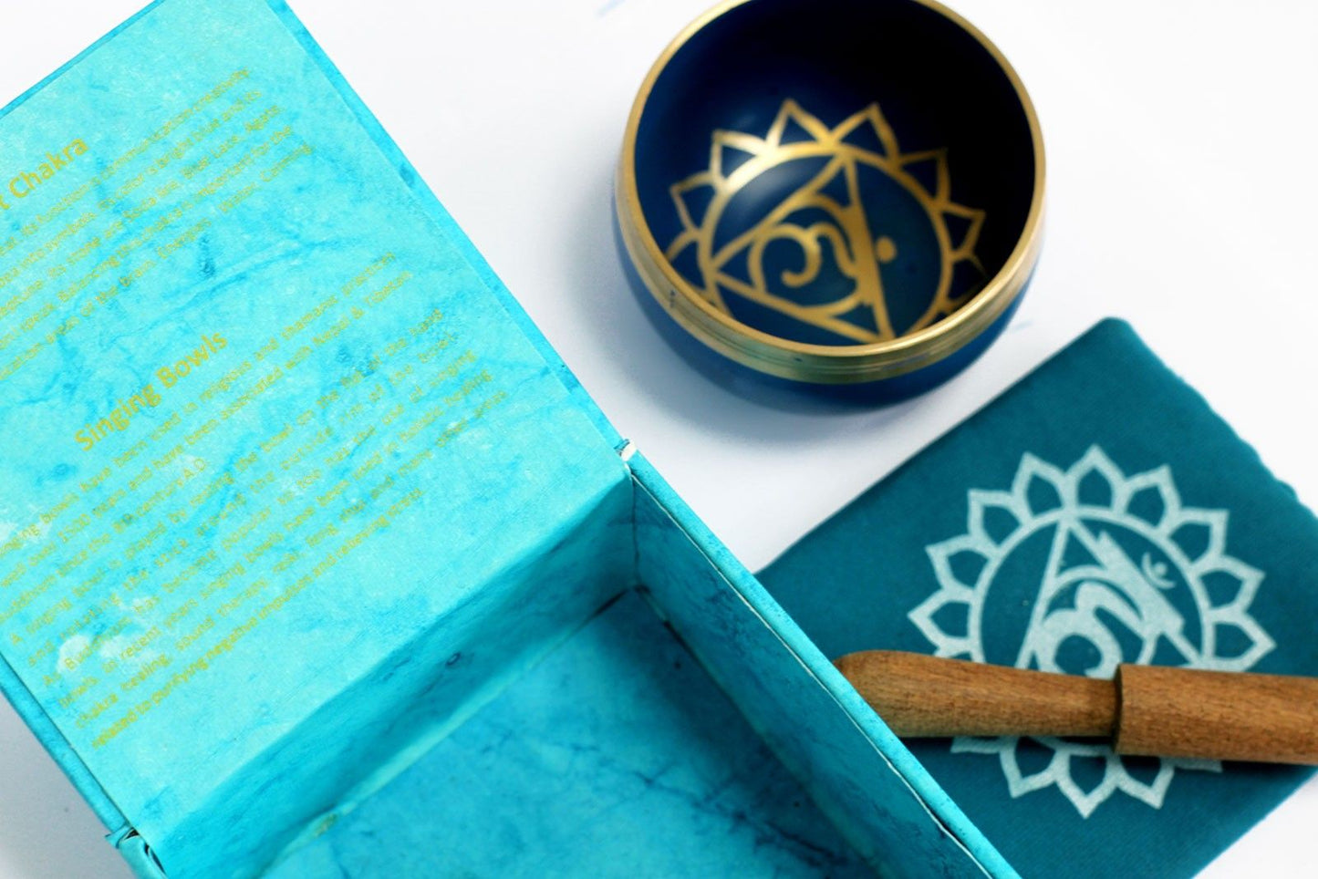 Alt Tag: Throat Chakra Singing Bowl – Approx. Frequency 876 Hz set with mallet, blue box and chakra symbol cloth