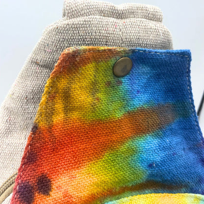 Tiedye Hemp Sling Shoulder Bag All Natural From Kathmandu close-up, rainbow tie-dye hemp fabric with button and gray woven strap
