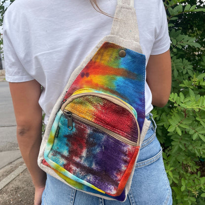 Alt Tag: Tiedye Hemp Sling Shoulder Bag All Natural From Kathmandu tie-dye hemp crossbody sling bag with front zipper pocket, worn outdoors