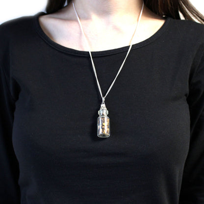 Alt Tag: Tiger Eye Bottled Gemstones Necklace – Natural Stone worn on silver chain, small glass bottle pendant with tiger eye stones
