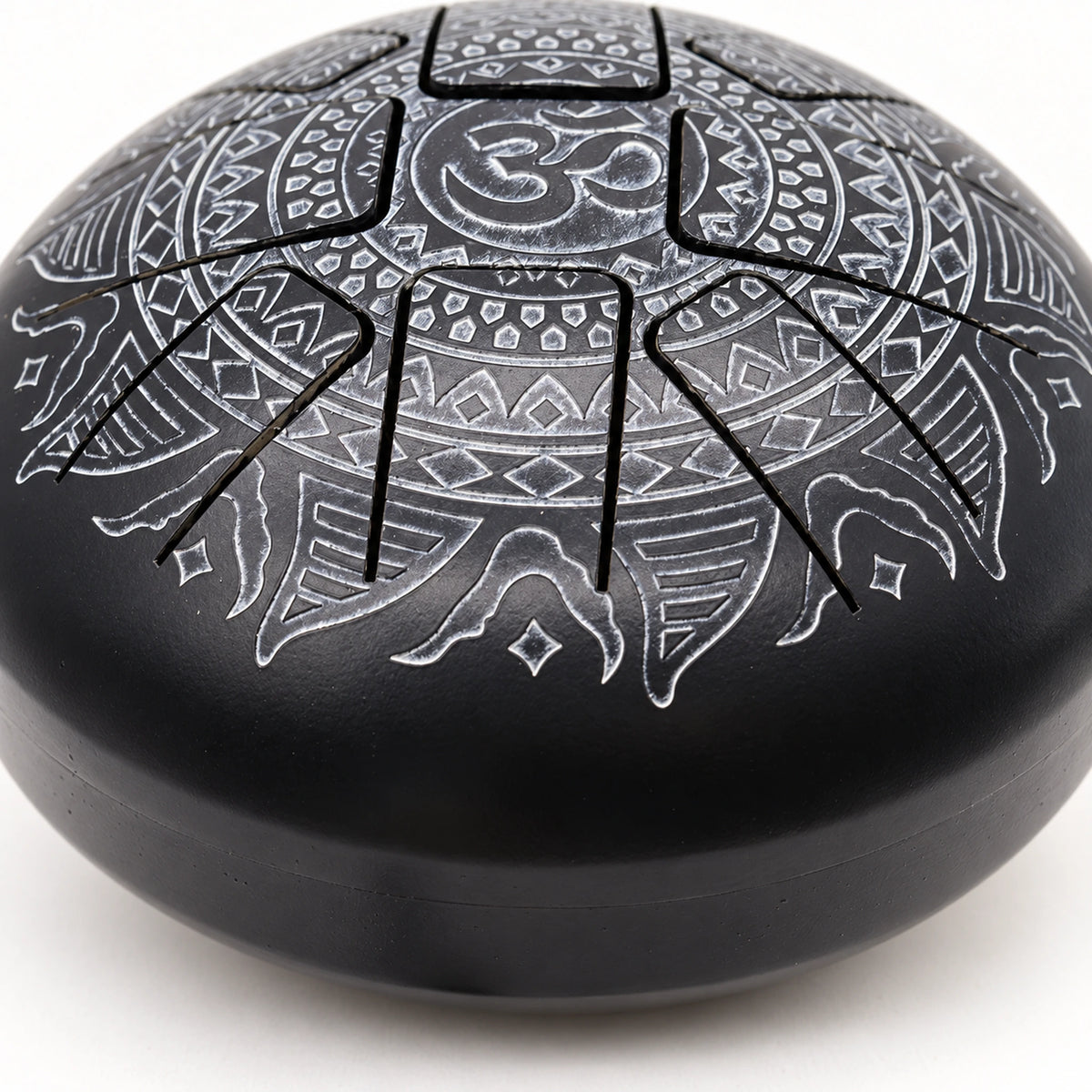 Detail of a cut tongue with silver-grey engraving and the transition into the drum's curved black sidewall.