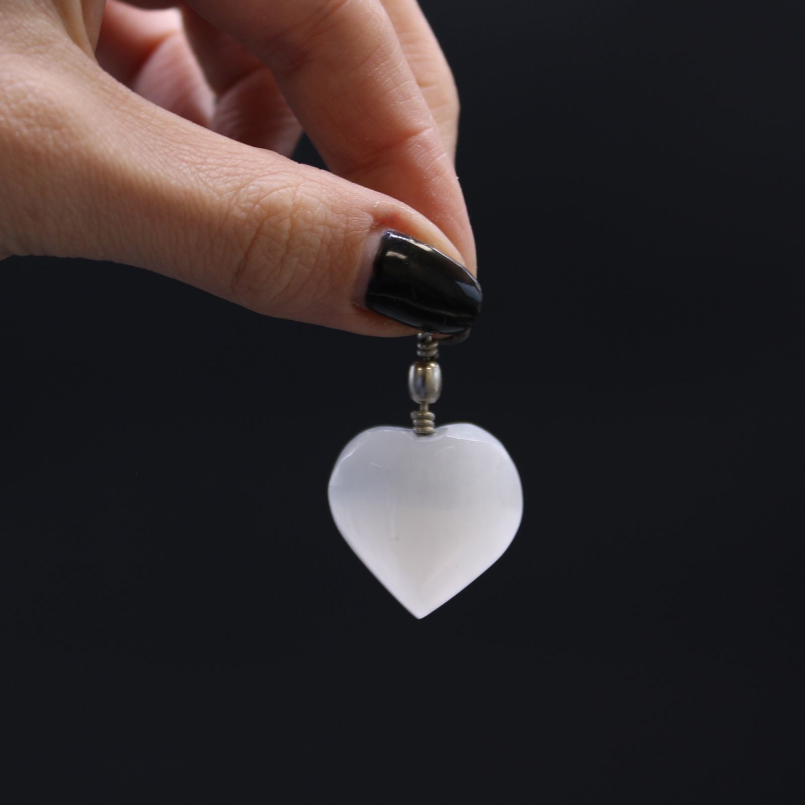 Alt Tag: Translucent Selenite Heart Pendant – 4x2.5 CM held by hand, nearly translucent heart-shaped selenite stone charm