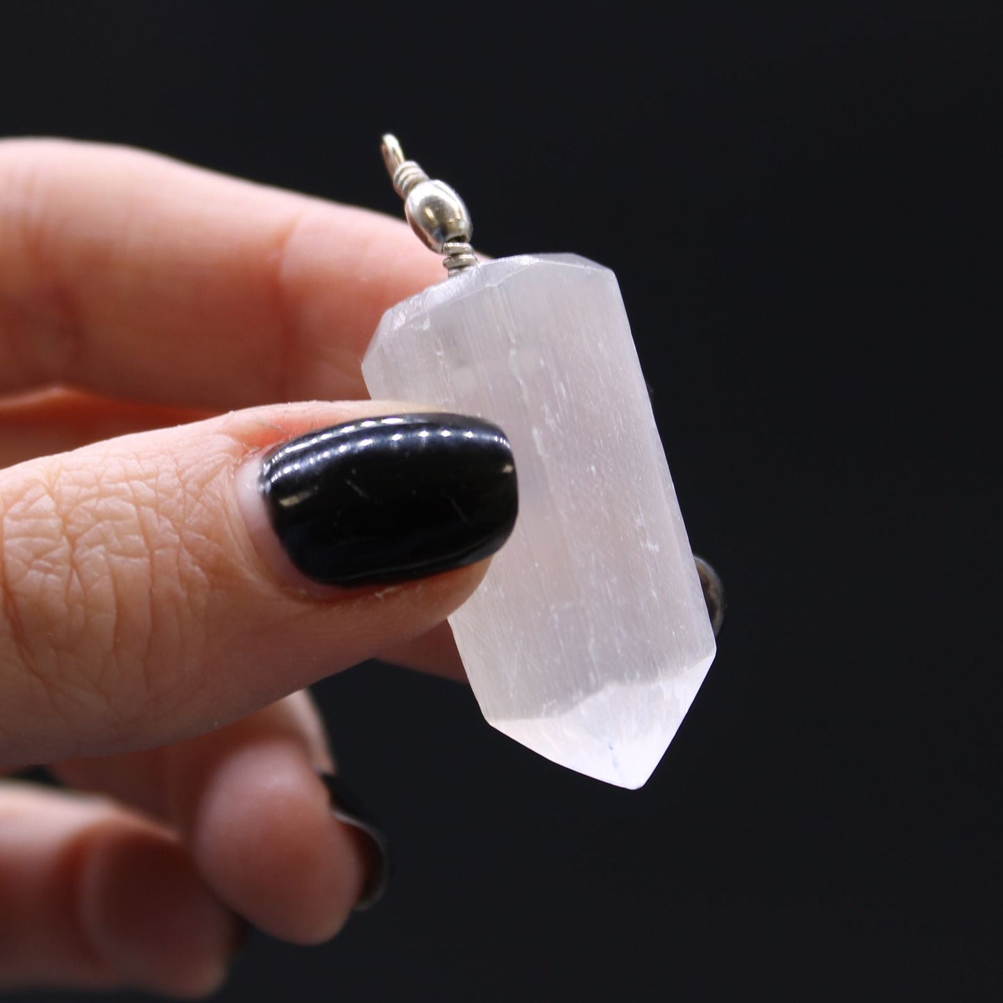 Alt Tag: Translucent Selenite Pendant – 5x1.5 CM held in hand, translucent selenite crystal point pendant with silver bail