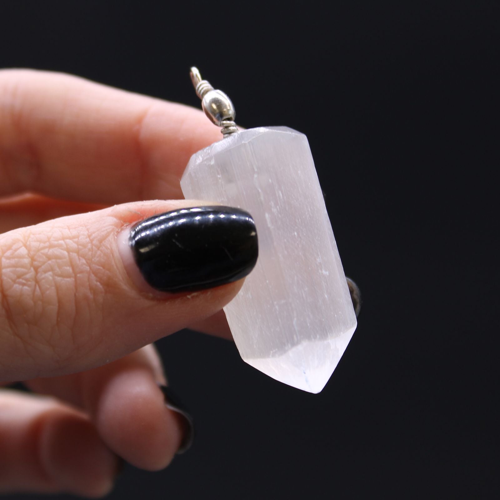 Alt Tag: Translucent Selenite Pendant – 5x1.5 CM held in hand, translucent selenite crystal point pendant with silver bail
