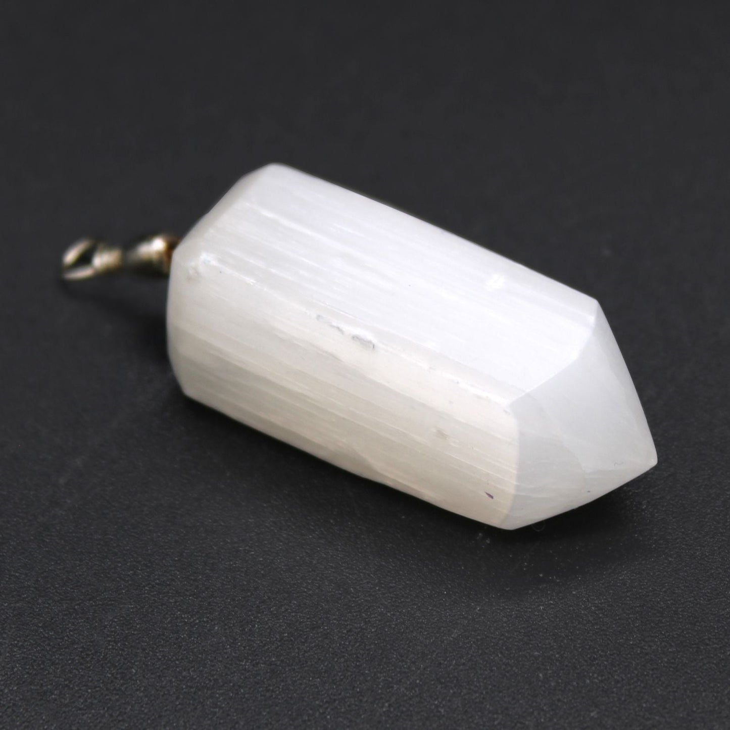 Alt Tag: Translucent Selenite Pendant – 5x1.5 CM white faceted selenite crystal pendant with metal bail, close-up on black background