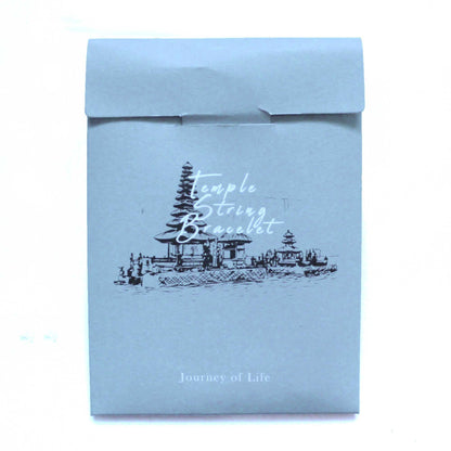 Alt-Tag: Tri Datu Temple String Bracelet – Umschlag der Verpackung „Journey of Life“ mit Tempel-Illustration und dem Text „Journey of Life“